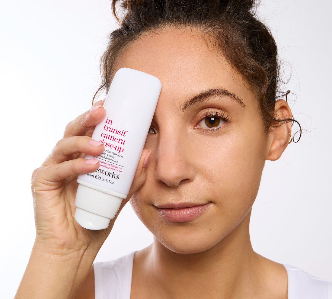A woman holds a bottle of thisworks in transit camera close up