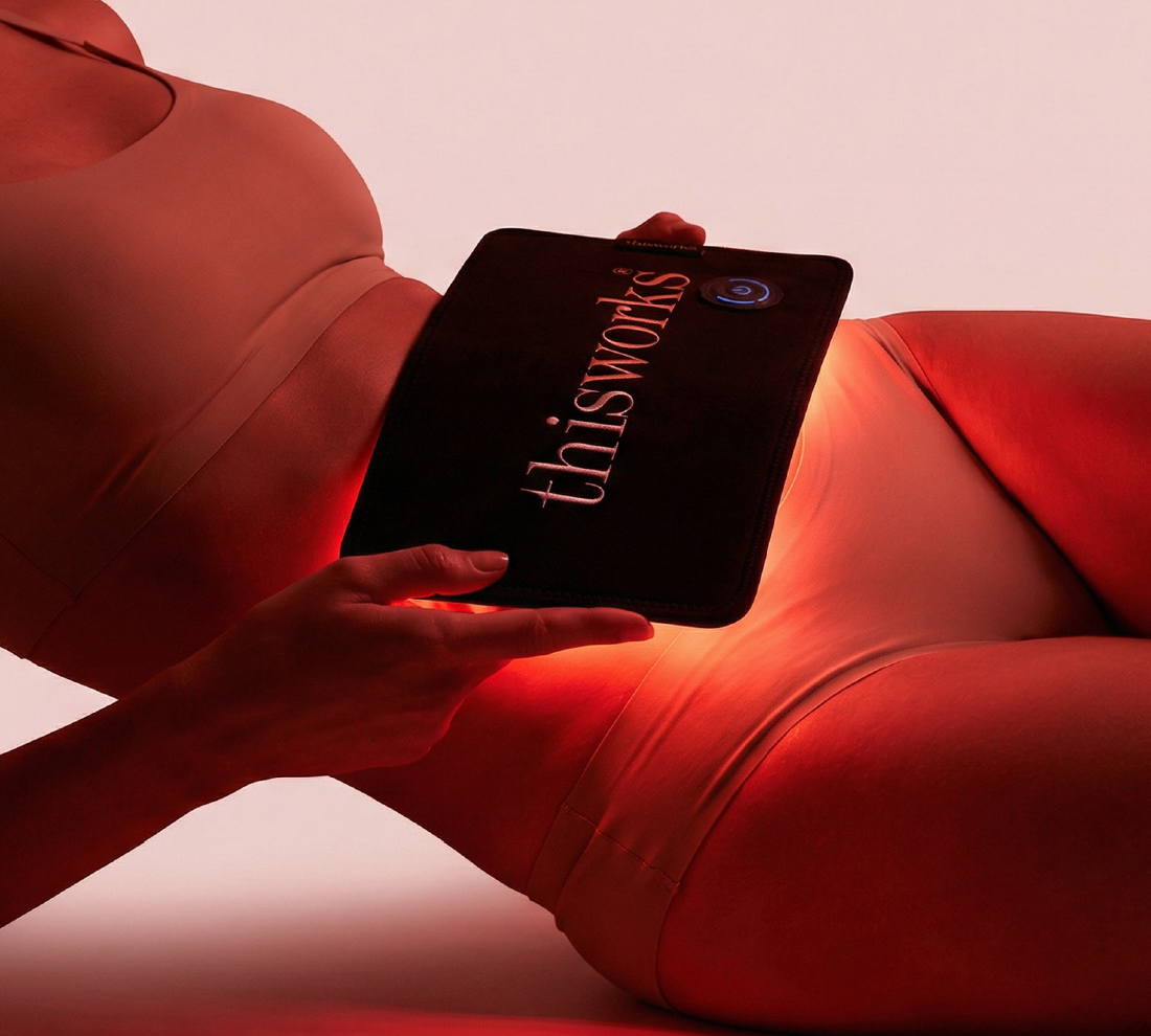 A person holds the red light body wrap to their stomach